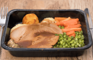 unappetising tv dinner of roast meat with peas, carrots, and roast potatoes