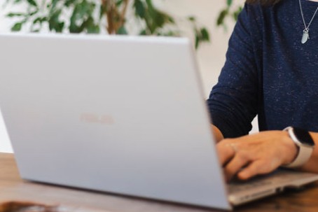 hands writing on laptop