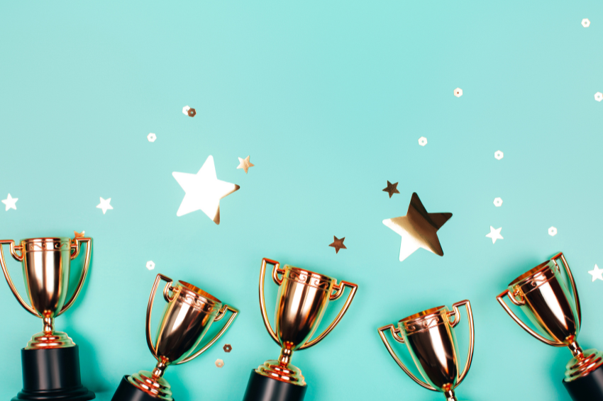 five trophies with gold stars on a blue background