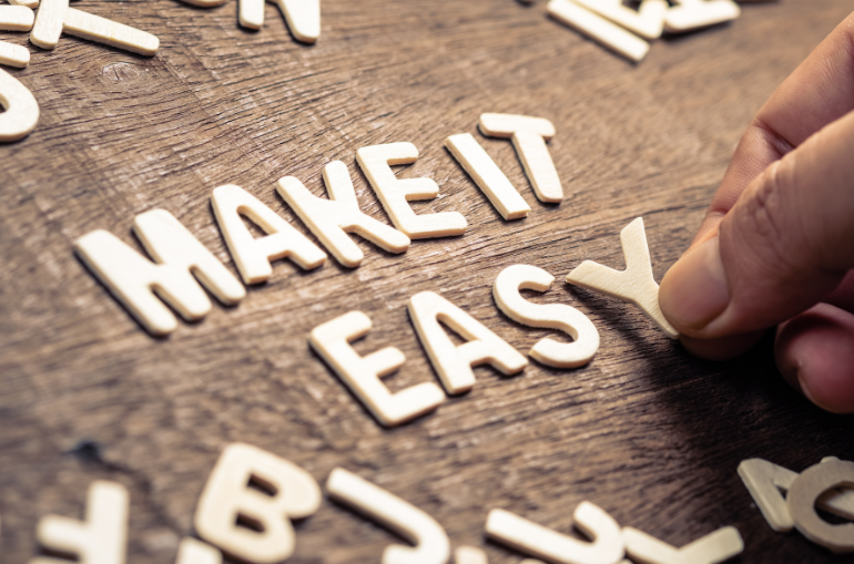 make it easy spelt out in cut-out letters. Shows a person's hand placing the y.
